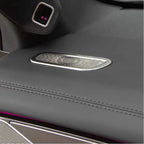 Close-up of a grey leather car interior accessory with a decorative silver metal insert.