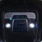 Black interior roof console with silver perforated trim and dual white LED reading lights.