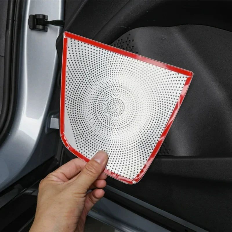 Hand applying a protective silver perforated door panel protector with red trim to a car door interior.