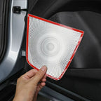 Hand applying a protective silver perforated door panel protector with red trim to a car door interior.