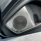 Silver metallic VNAUDIO car door speaker grille with a textured black circular pattern.
