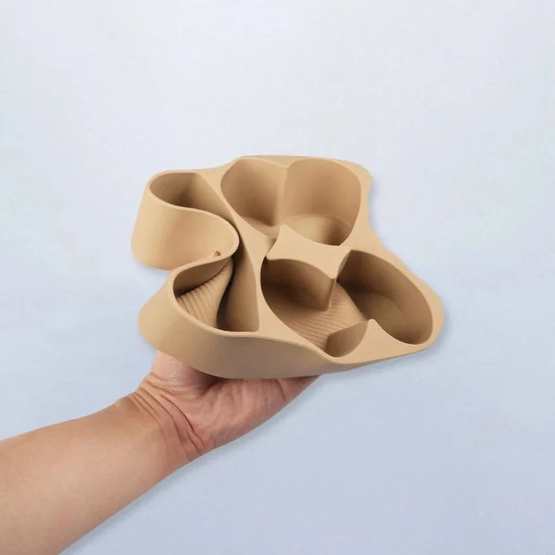 Hand holding a beige silicone center console organizer tray with custom compartments.