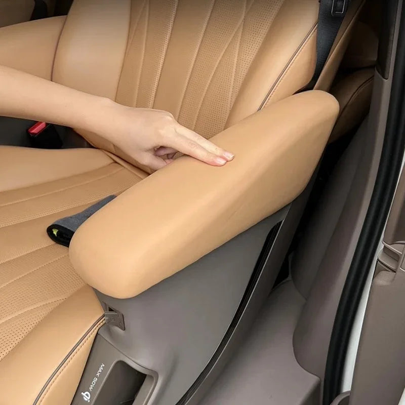 Tan leather armrest cover installed on a vehicle seat for enhanced comfort and protection.