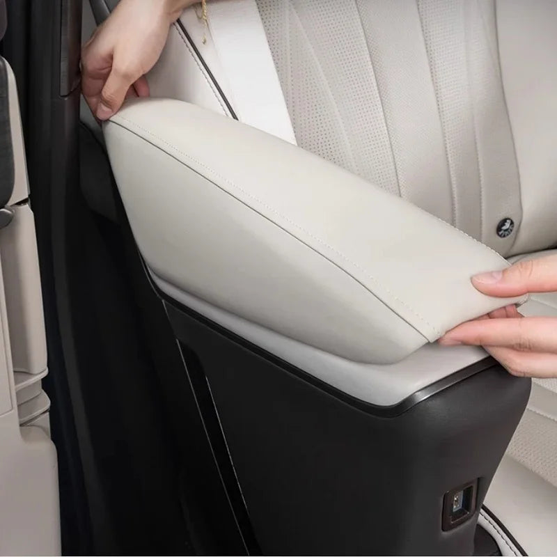 Close-up of a premium light gray leather armrest cover for a car interior.