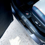 Black sleek ATTO 3 door sill protector plate installed on a car threshold.