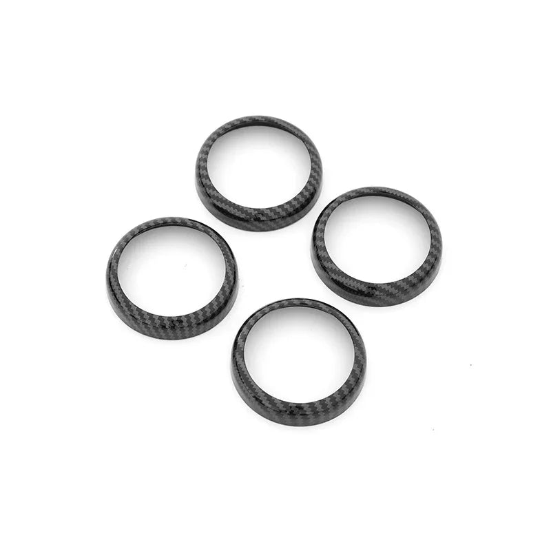 Set of four black carbon fiber texture ring trim accessories for car interior enhancement.