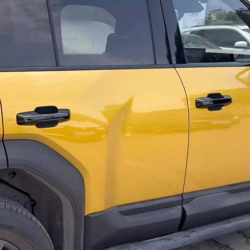 Dented yellow car door panel showing impact damage on the side bodywork.