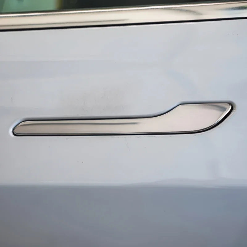 Silver chrome door handle protector installed on a white car door