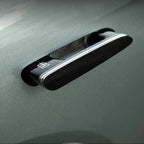 Glossy black car door handle cover with sleek chrome trim and white emblem detail.