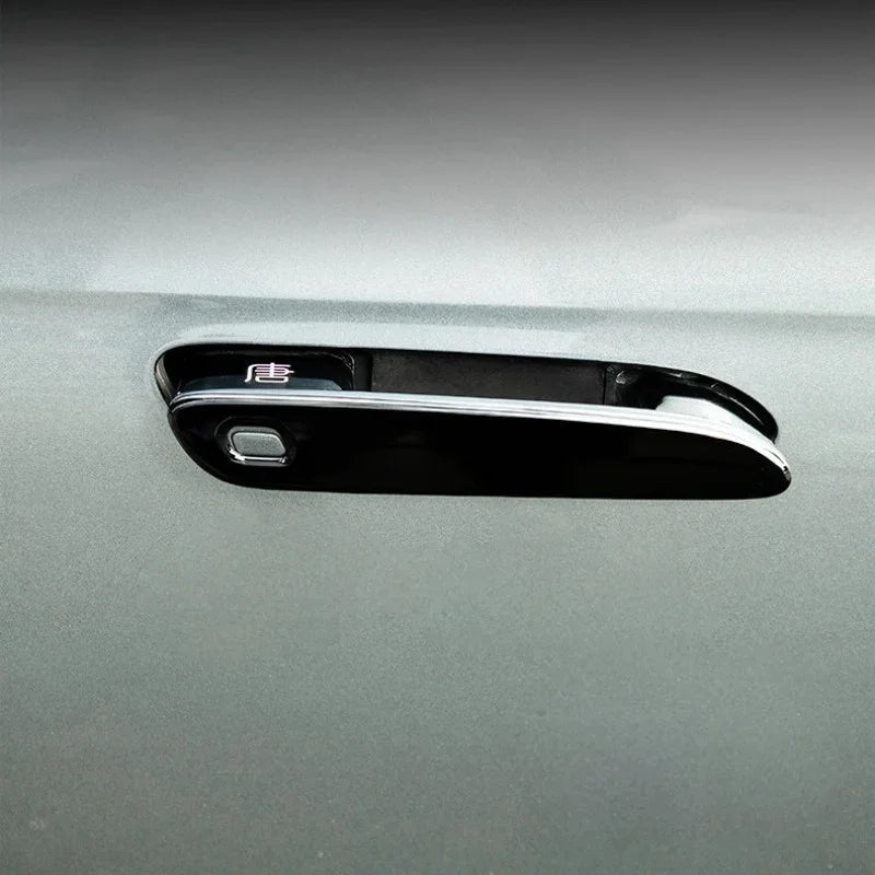 Glossy black car door handle cover with chrome trim and Chinese character emblem.