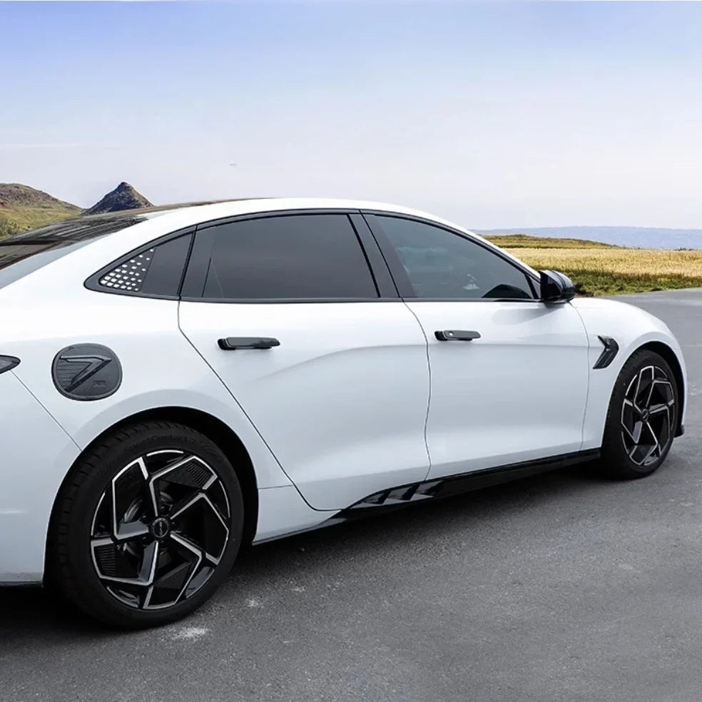 White BYD sedan featuring black carbon fiber side skirt accents and tinted windows.