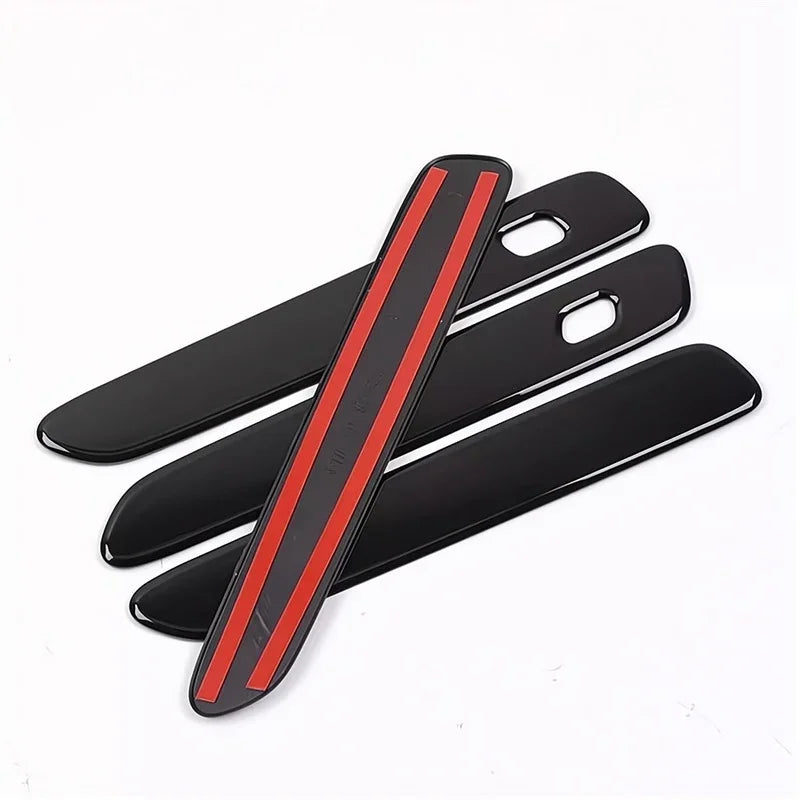 Set of black glossy door sill protectors featuring distinctive red decorative stripes.