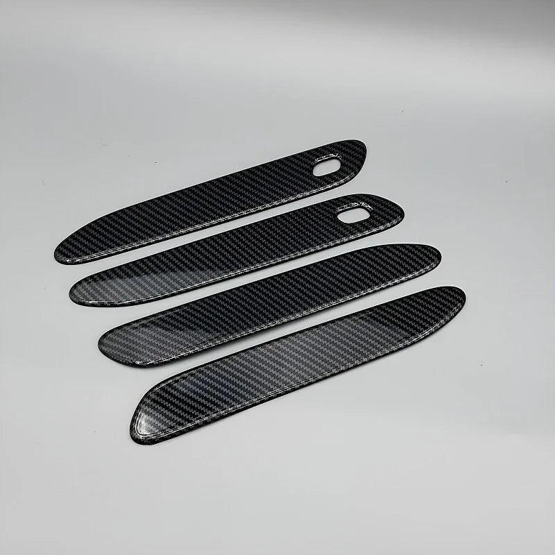 Four black carbon fiber texture door sill protectors for BYD vehicle interior protection.