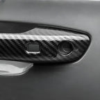Glossy black carbon fiber patterned car door handle cover for enhanced protection and style.