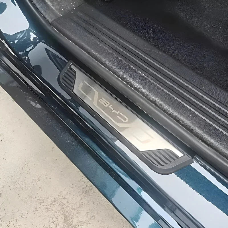 Silver BYD branded brushed metal door sill protector installed on a dark teal car