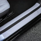 Sleek black protective door sill guard installed on a light grey car interior trim.