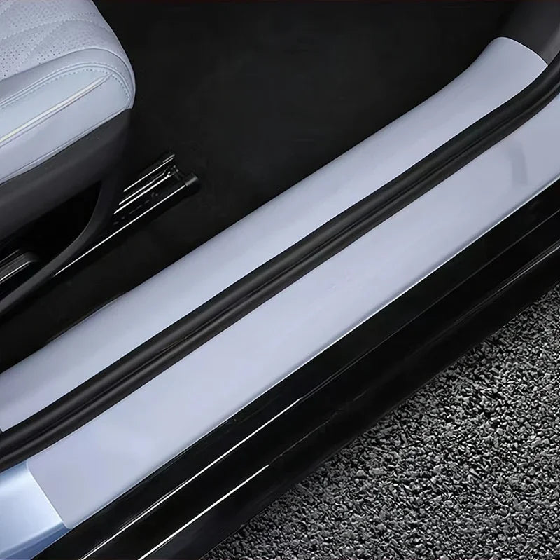 Sleek black protective door sill guard installed on a light grey car interior trim.