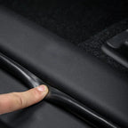 Black flexible TPE edge protector strip being applied to a car door sill for wear protection.