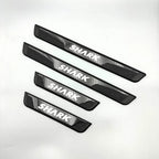 Set of four black textured car door sill protectors featuring white SHARK branding.