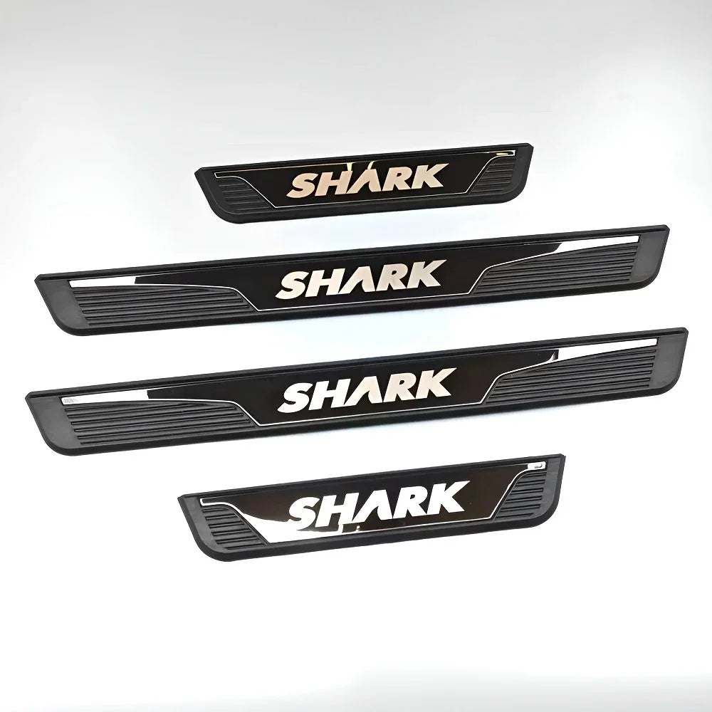 Four black and silver metal SHARK car door sill protectors with a sleek, modern design.