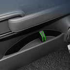 Black leather door panel with a custom-fit interior storage compartment featuring green trim.