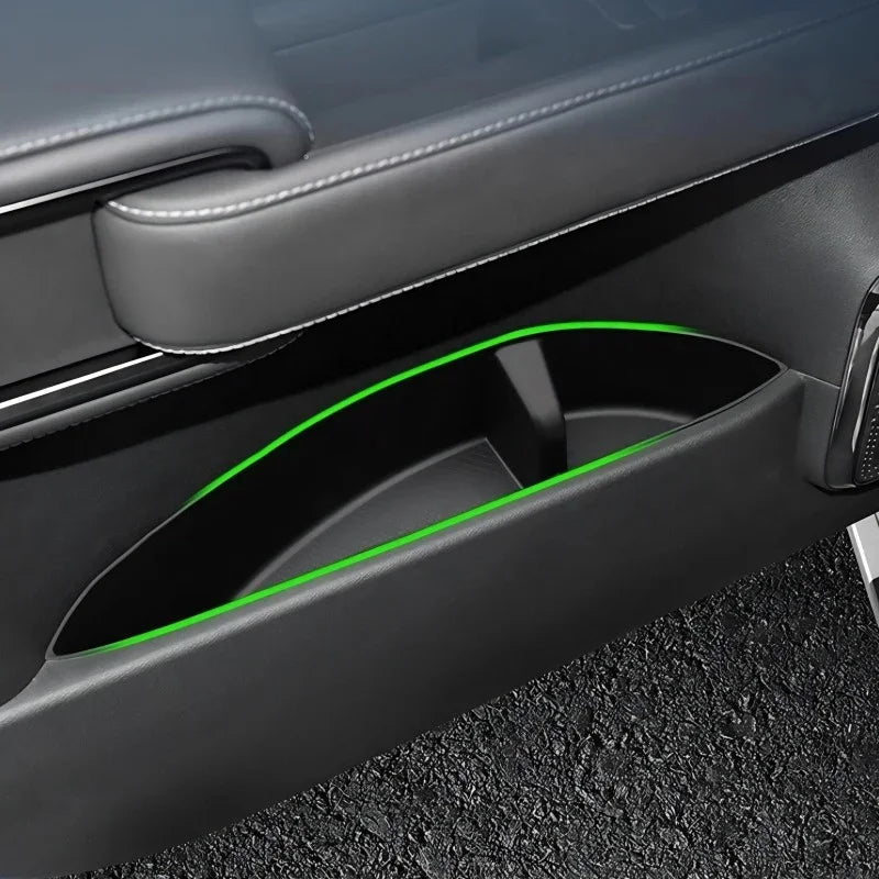 Black leather car door pocket featuring vibrant green LED ambient lighting.