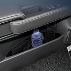Black leather-textured car door pocket storage holding a water bottle and black umbrella.