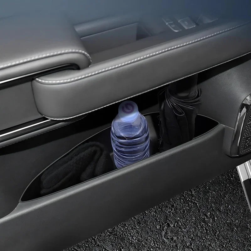 Black leather-textured car door pocket storage holding a water bottle and black umbrella.
