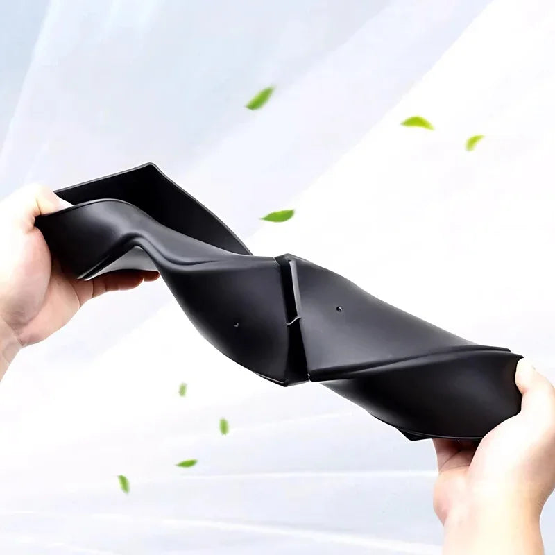 Flexible black TPE car floor mat being folded to demonstrate durability and elasticity.