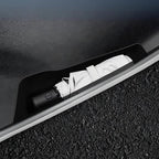 Black car trunk umbrella storage compartment with a white folded umbrella inside
