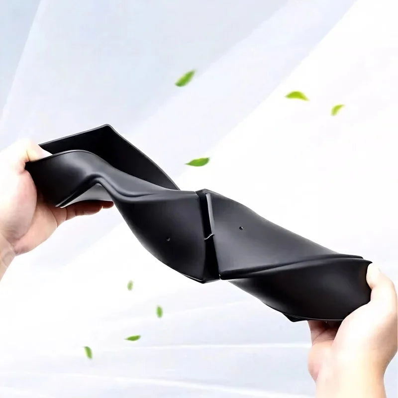 Flexible black TPE car floor mat being bent to demonstrate durability and material elasticity.