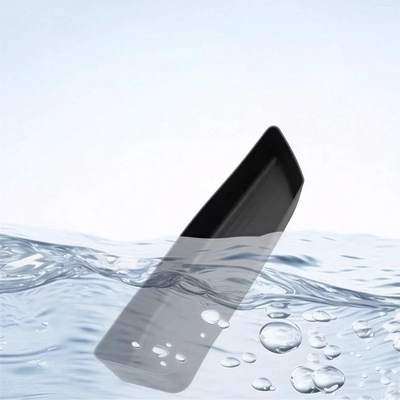 Black waterproof TPE car trunk mat partially submerged in clear water.
