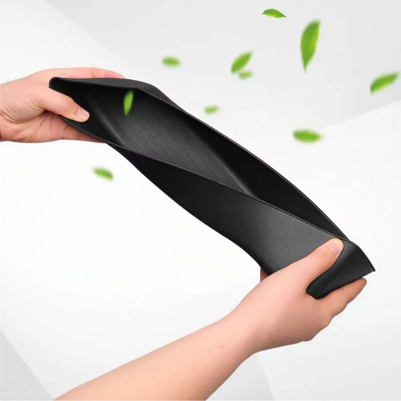 Flexible black TPE car floor mat being bent to demonstrate durability and material elasticity.