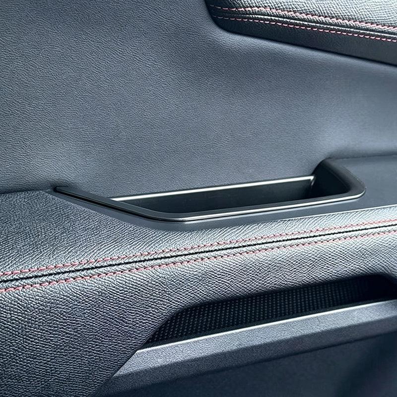 Premium black textured leather car door panel with elegant red contrast stitching.