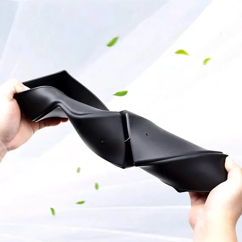 Flexible black TPE car floor mat being bent to demonstrate durable and resilient material.