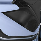 Close-up of a luxury car interior with light blue leather upholstery and a black Dynaudio speaker grill.