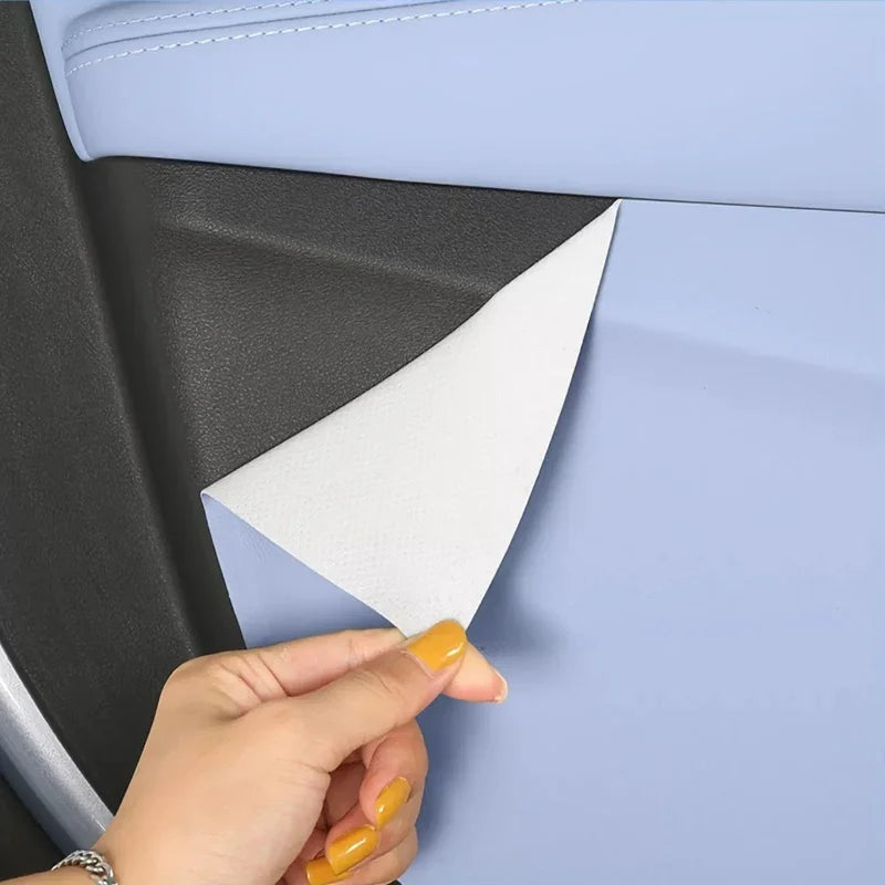 Peeling back light blue faux leather protective film to reveal durable black interior surface.