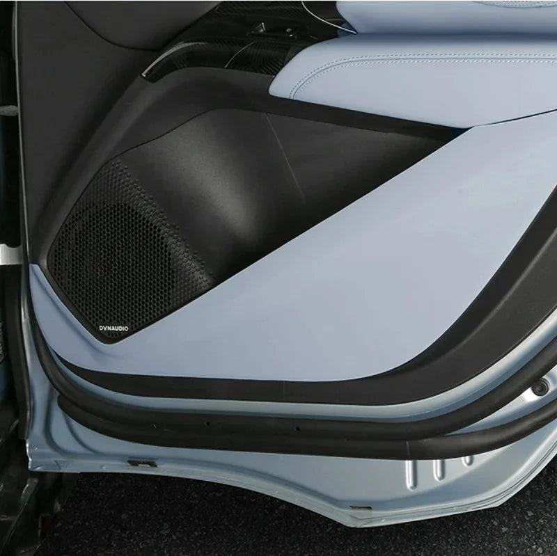 Light blue and black premium leather car door panel with integrated mesh speaker grille.