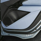 Light blue leather and black textured trim car door panel with integrated speaker grille.