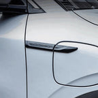 Black matte BYD design emblem on a silver car charging port cover.