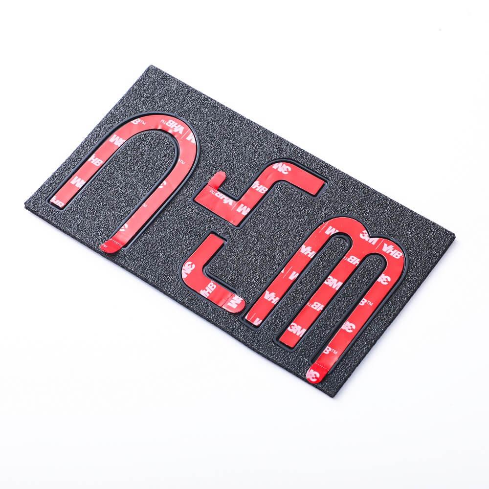Red 3D emblem letters with black textured backing for automotive decoration.