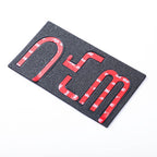 Red 3D emblem letters with black textured backing for automotive decoration.