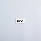 White plastic emblem featuring the 'EV' text in bold black lettering.