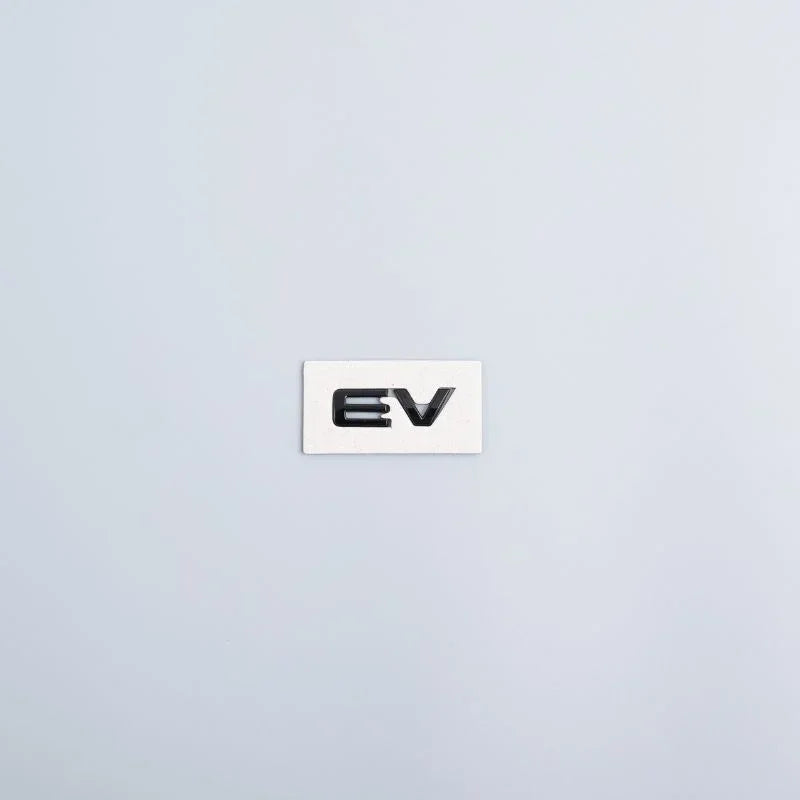 White plastic emblem featuring the 'EV' text in bold black lettering.