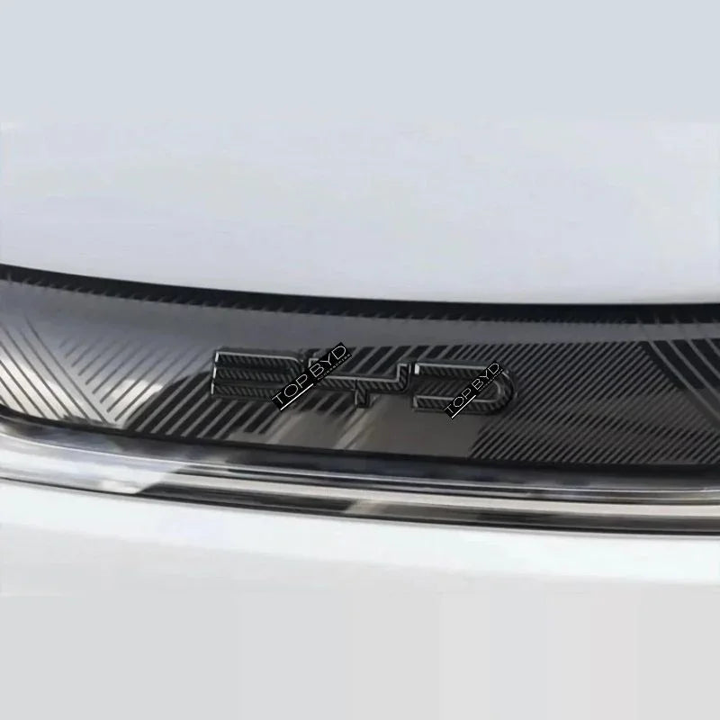 Close-up of a black carbon fiber textured car accessory with a glossy finish.