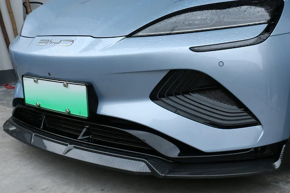Black carbon fiber front bumper lip spoiler for light blue BYD vehicle.