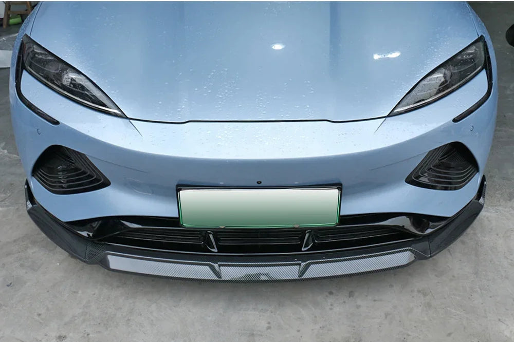 Light blue car front bumper featuring a sleek black carbon fiber front lip spoiler.