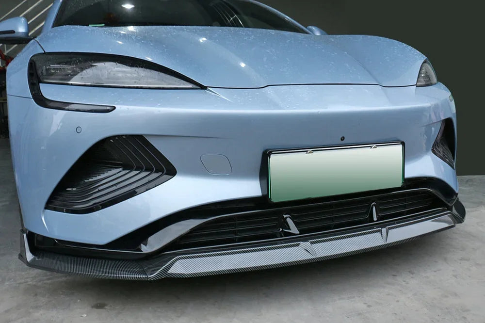 Front view of a light blue BYD sedan featuring a sleek black carbon fiber front lip spoiler.