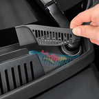Hand lifting a black plastic slotted organizer tray from a car console compartment.