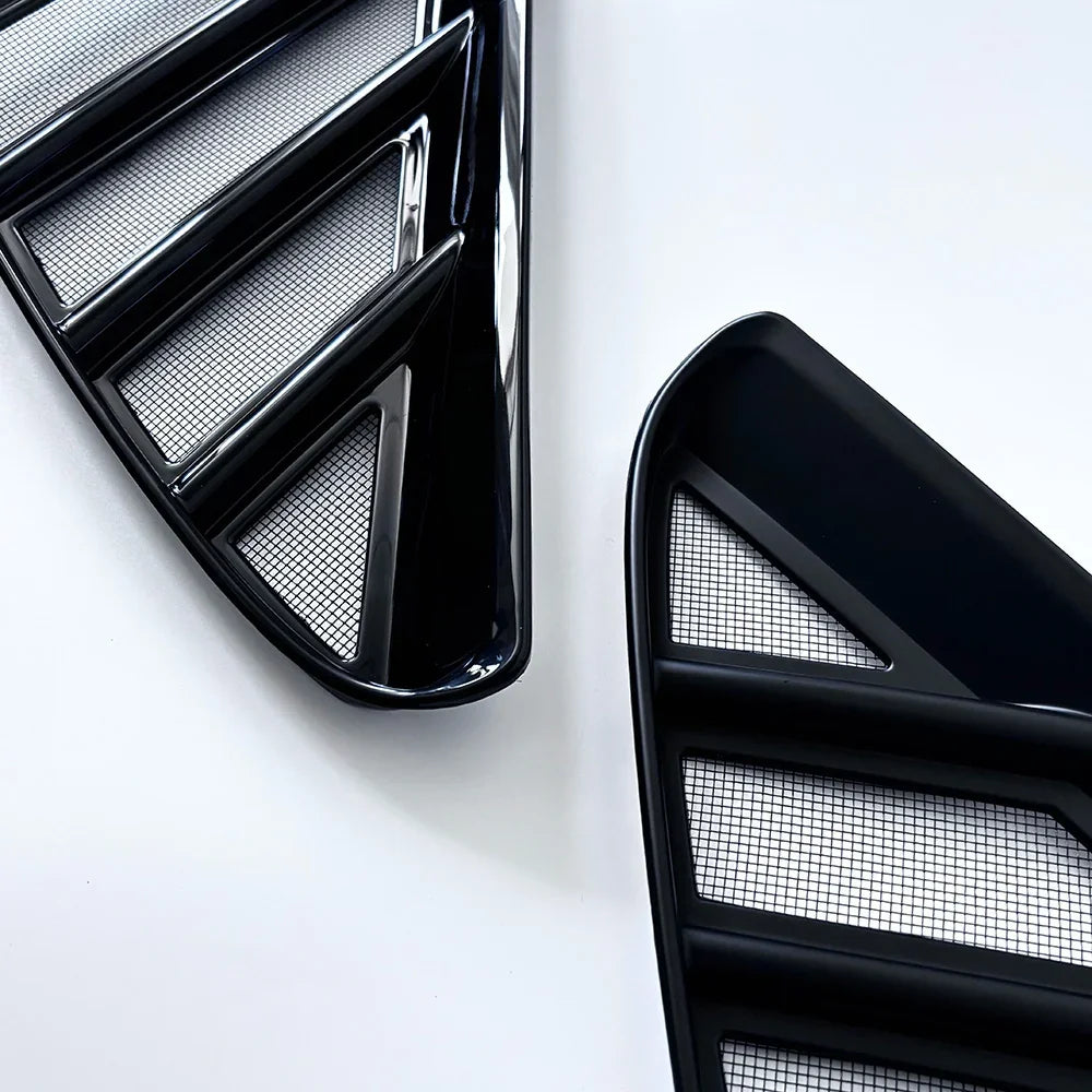 Glossy black aftermarket car grille vent with silver mesh inserts.